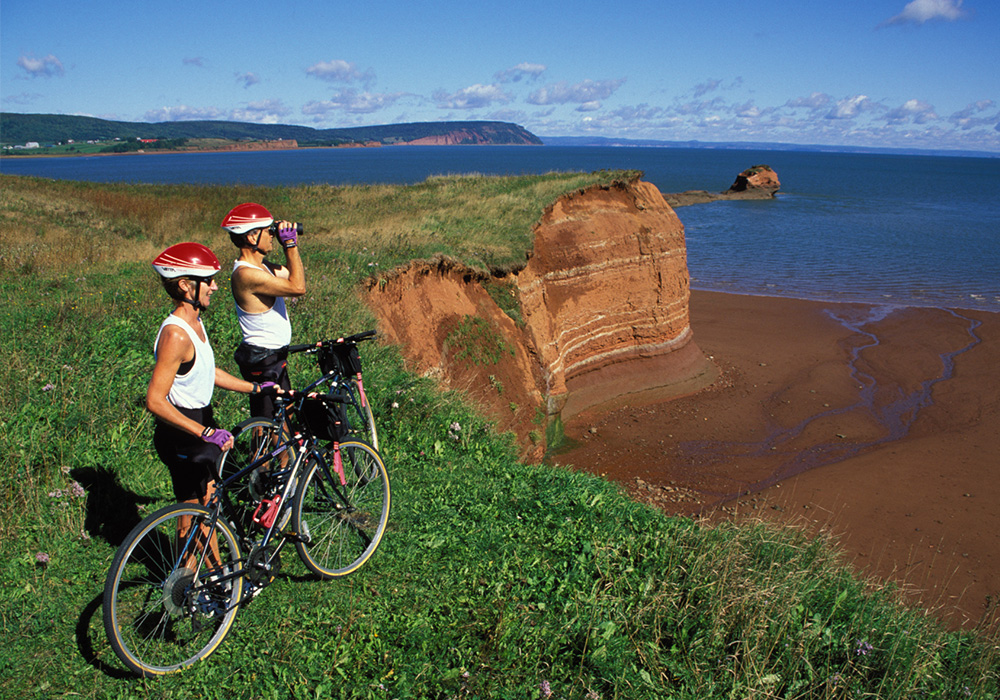 An image rendering of two bikers with binoculars in Annapolis Valley by the water.