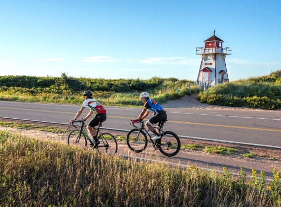 Cyclist in PEI with Lighthouse in the background