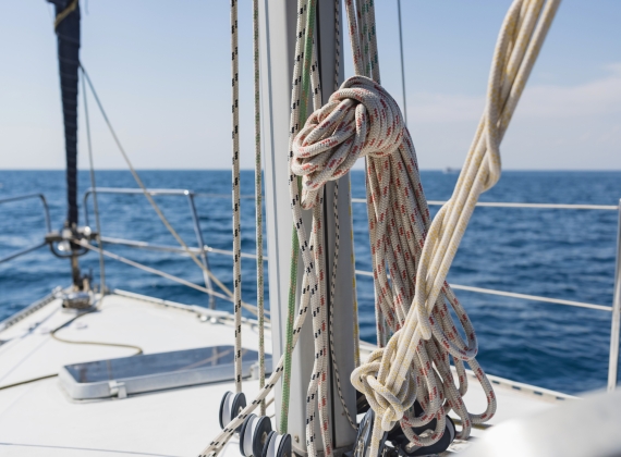 Sailboat yacht sailing in the sea at blue summer sky